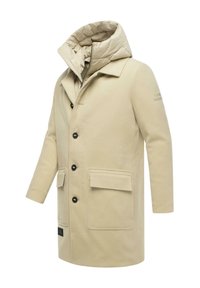 Beige hosszú kabát, puha anyagból, puffadt belső gallérral, fekete gombokkal, két elülső zsebből és varrással díszítve.