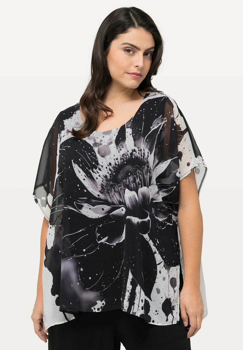 Zwart-wit blouse met een grote bloemenprint en spetterdetails, gemaakt van lichtgewicht doorschijnende stof, met brede mouwen en een ontspannen pasvorm.