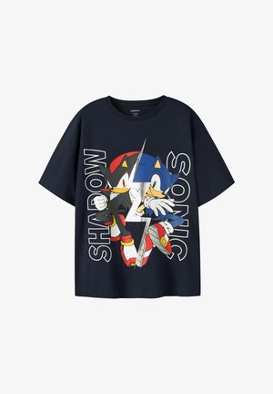 Marineblå t-shirt med grafik af Sonic og Shadow the Hedgehog karakterer adskilt af en sølv lyn, med deres navne i stor tekst.