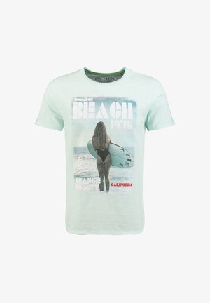 Hellgrünes T-Shirt mit einem Strandmotiv, das eine Frau zeigt, die ein Surfbrett hält, mit dem Text "Beach 1976" und "California".