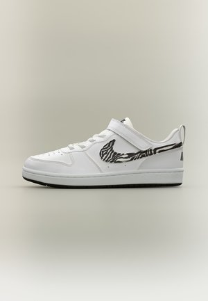 Λευκό sneaker χαμηλού τύπου με ασπρόμαυρο ζεβρέ σχέδιο Nike Swoosh, ιμάντα με βέλκρο, κορδόνια και μαύρες λεπτομέρειες στην σόλα.