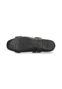 Sandalia negra con suela de goma texturizada, presenta un diseño plano y correas ajustables para un ajuste personalizado.