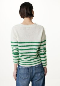 Suéter suave de mezcla de lana con rayas horizontales verdes y blancas, cuello redondo y un corte relajado, combinado con jeans azules.