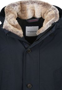 Donkerblauwe parka met een capuchon gevoerd met namaakbont, voorzien van rits- en knoopsluitingen, twee steekzakken aan de voorkant en een merklabel aan de binnenkant.