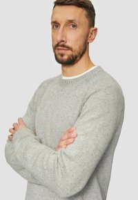 Jasnoszary sweter z dzianiny o teksturowej tkaninie i plisowanych akcentach. Okrągły dekolt, długie rękawy, dopasowane mankiety i regularny fason.