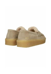 Beige suede loafers with thick gum soles and plush shearling lining, viewed from the back and angled to the side.