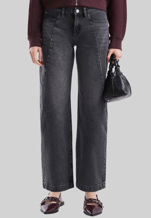 Hochtaillierte, weit geschnittene schwarze Denim-Jeans mit leichter Textur, Fünf-Taschen-Design und vorderem Knopfverschluss.