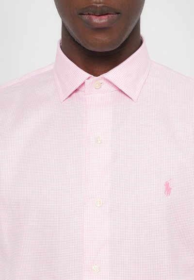 Ροζ ανοιχτό καρό πουκάμισο με κολάρο τύπου spread, που διαθέτει λευκά κουμπιά και ένα μικρό ροζ λογότυπο στο αριστερό στήθος.