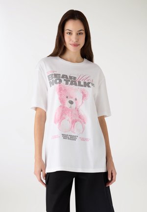 Biała oversize koszulka z nadrukiem różowego misia i kolorowymi napisami. Miękka tkanina, krótkie rękawy i luźny krój.