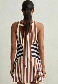 Vestido a rayas con franjas verticales en marrón y blanco y un detalle de lazo en la parte posterior. Tejido ligero con un dobladillo acampanado.