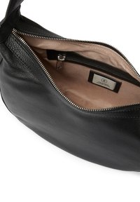 Svart läderhandväska med rundad form, blixtlåsets topp och beige foder. Har ett innerfack med blixtlås och varumärkesetikett.