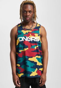Top militariei cu camouflage, având un amestec de modele verzi, roșii, galbene și albastre; text mare alb care spune "DNGRS"; realizat dintr-un material moale.