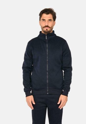 Giacca in pile blu navy con zip, colletto alto, polsini e orlo a costine, caratterizzata da una texture liscia e una zip frontale a tutta lunghezza.