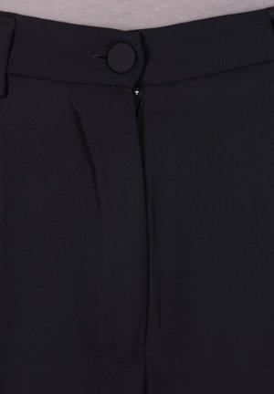 Pantaloni neri con una texture di tessuto liscia, caratterizzati da una chiusura frontale con bottone, zip e pieghe per un design sartoriale.