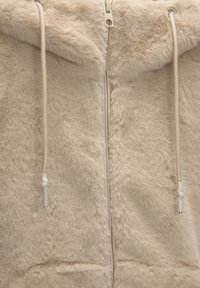 Beige faux fur zip-up hoodie med en lækker tekstur, der har en høj krave, beige snore og en central lynlås.