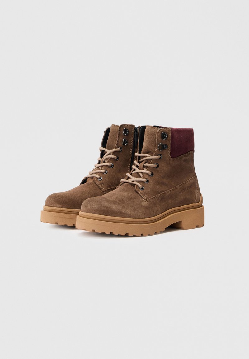 Brown suede ankle boots with a maroon back, textured surface, round toe, and light rubber outsole. Laced with beige laces and metal eyelets.