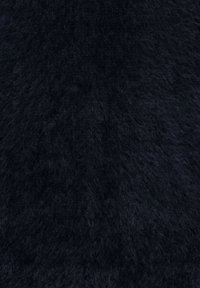 Närbild av fluffigt, mörk marinblått stickat tyg med en mjuk, luddfull textur och ett subtilt ribbat mönster.