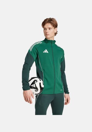 Groene sportjack met witte strepen en rits, lange mouwen, gecombineerd met een zwart-witte voetbal, textuur stof.