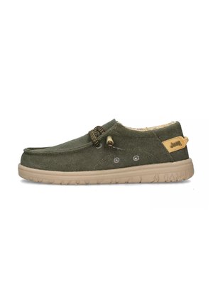 Scarpa slip-on verde in tela con suola in gomma beige, caratterizzata da lacci decorativi, due fori per lacci e un'etichetta con logo sul tallone.