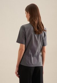 Kurzärmlige Bluse in Anthrazitgrau mit subtilen Karomuster, strukturiertem Kragen und taillierter Passform, hergestellt aus leichtem Material.