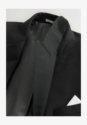 Czarny żakiet z teksturowanej tkaniny, elegancki kołnierz i kontrastowy biały poszetka. Podszewka z subtelnym wzorem.