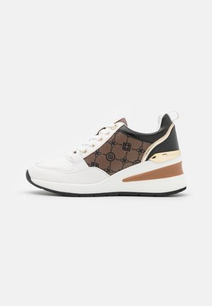 Baskets blanches et brunes avec un design texturé, présentant des accents dorés, un talon noir et une semelle blanche. Les lacets maintiennent l'avant.