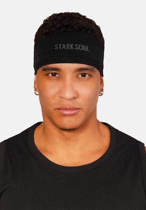 Black fabric headband with ribbed texture, featuring the text "STARK SOUL" in gray, worn on a person with short curly hair.