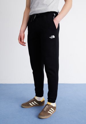 Pantalones de chándal negros con un corte ajustado, que cuentan con una cintura elástica con cordón, bolsillos laterales y un logo blanco en el muslo izquierdo.