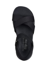 Schwarze Slipper-Sandalen mit elastischen Riemen, einer gepolsterten Innensohle und einer glatt strukturierten Sohle. Der Markenname "Skechers" ist sichtbar.