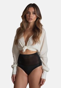 Witte geknoopte crop top met lange mouwen, gecombineerd met hoge zwarte doorschijnende onderbroek met een gladde textuur en gegolfde rand.