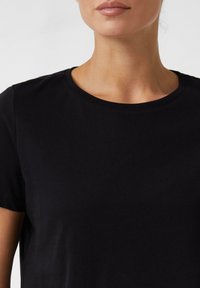 Zwarte katoenen T-shirt met een ronde halslijn en korte mouwen. Gladde textuur, minimalistisch ontwerp en geen zichtbare patronen of accenten.