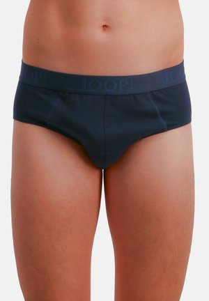 Torso maschile che indossa slip blu scuro con il logo "JOOP!" sulla fascia in vita, su uno sfondo bianco uniforme.