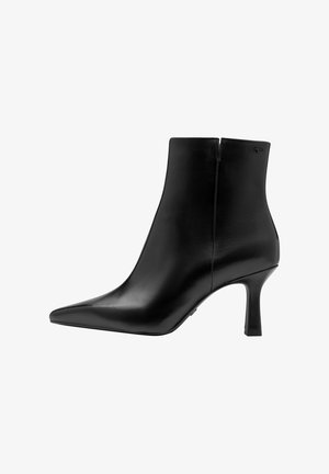 Bottine en cuir noir avec un bout pointu et un talon moyen slim, dotée d'une fermeture éclair latérale et d'une finition lisse.