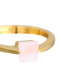Bracciale cuff in metallo color oro con una pietra di quarzo rosa quadrata e liscia, che presenta un design minimalista con linee pulite.