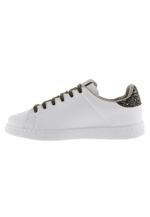 Sneaker bianca in pelle con suola in gomma piatta, lacci verdi e un accento glitterato nero sul tallone. Punta rotonda e design minimalista.