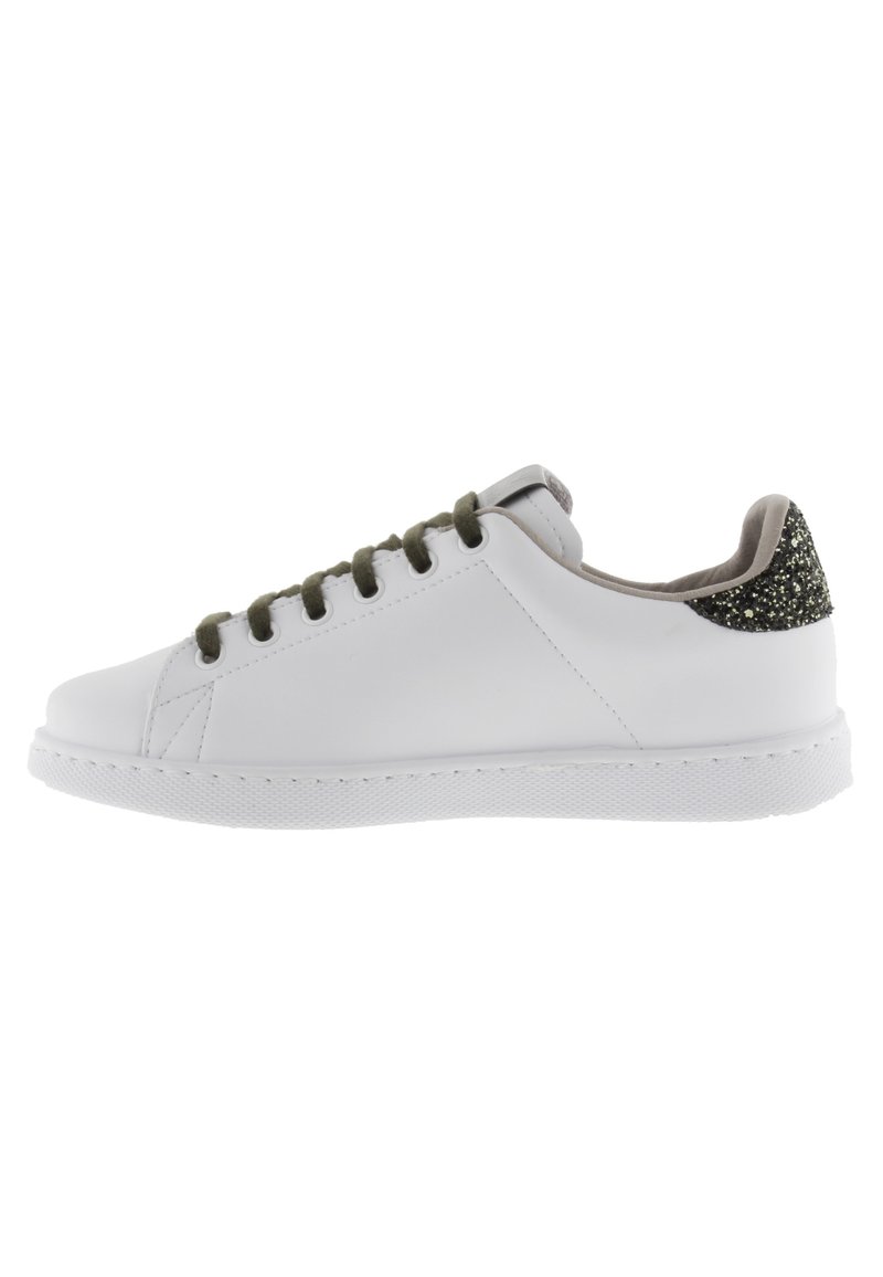 Sneaker bianca in pelle con suola in gomma piatta, lacci verdi e un accento glitterato nero sul tallone. Punta rotonda e design minimalista.
