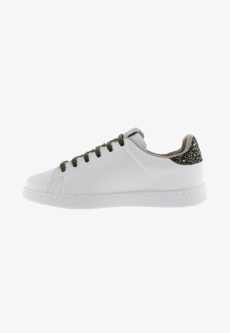 Sneaker bianca in pelle con suola in gomma piatta, lacci verdi e un accento glitterato nero sul tallone. Punta rotonda e design minimalista.