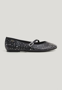 Babies ballerines en cuir noir avec un pointu, une fine lanière sur le pied et ornées de clous en argent. Conception à semelle plate.