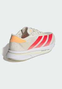 Lightweight running shoe featuring a white mesh upper with pink stripes, an orange heel accent, and a white textured sole.
