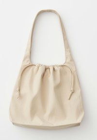 Beige zachte leren schoudertas met geplooide trekkoordsluiting en een enkele brede riem, weergegeven op een witte achtergrond.