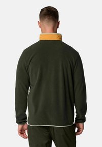 Green fleece jacket with a yellow collar, featuring a soft texture and contrasting stitching along the hem and cuffs.