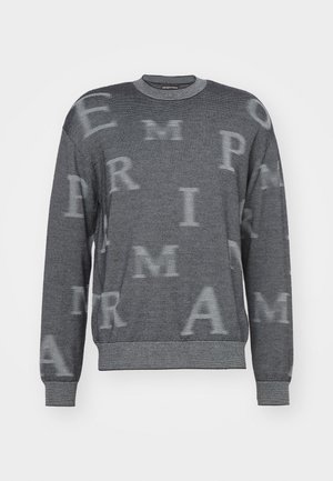 Maglione grigio a maniche lunghe, con un design a righe orizzontali e grandi lettere sbiadite su tutta la superficie. Collo e polsini a coste.