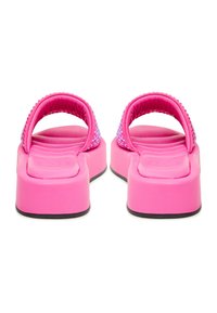 Une paire de sandales à plateforme rose vif avec des semelles rembourrées et des brides scintillantes, vues de l'arrière sur un fond blanc.