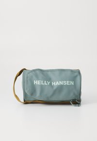 Jasnoniebieska i brązowa kosmetyczka Helly Hansen z klapą i uchwytem do noszenia na białym tle.