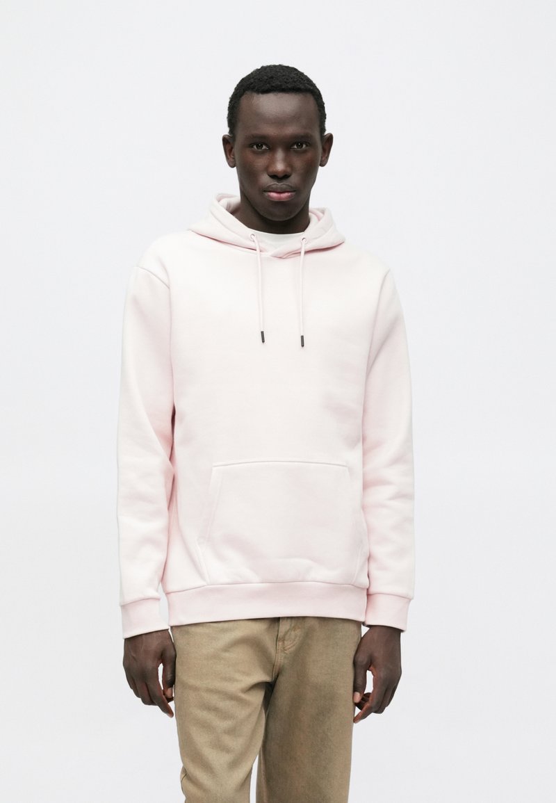 Hellrosa Kapuzenpullover mit Kängurutasche, verstellbaren Kordeln, gerippten Bündchen und Saum. Hergestellt aus weichem Stoff mit schlichtem Design.