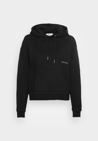 Felpa nera con cappuccio realizzata in tessuto morbido, dotata di tasca a marsupio, cordini e un logo sul petto. Design semplice con una vestibilità cropped.