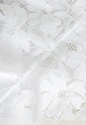 Material alb din dantelă florală cu modele detaliate, având o țesătură texturată și deschisă. Marginile sunt ondulate, evidențiind motive florale delicate.