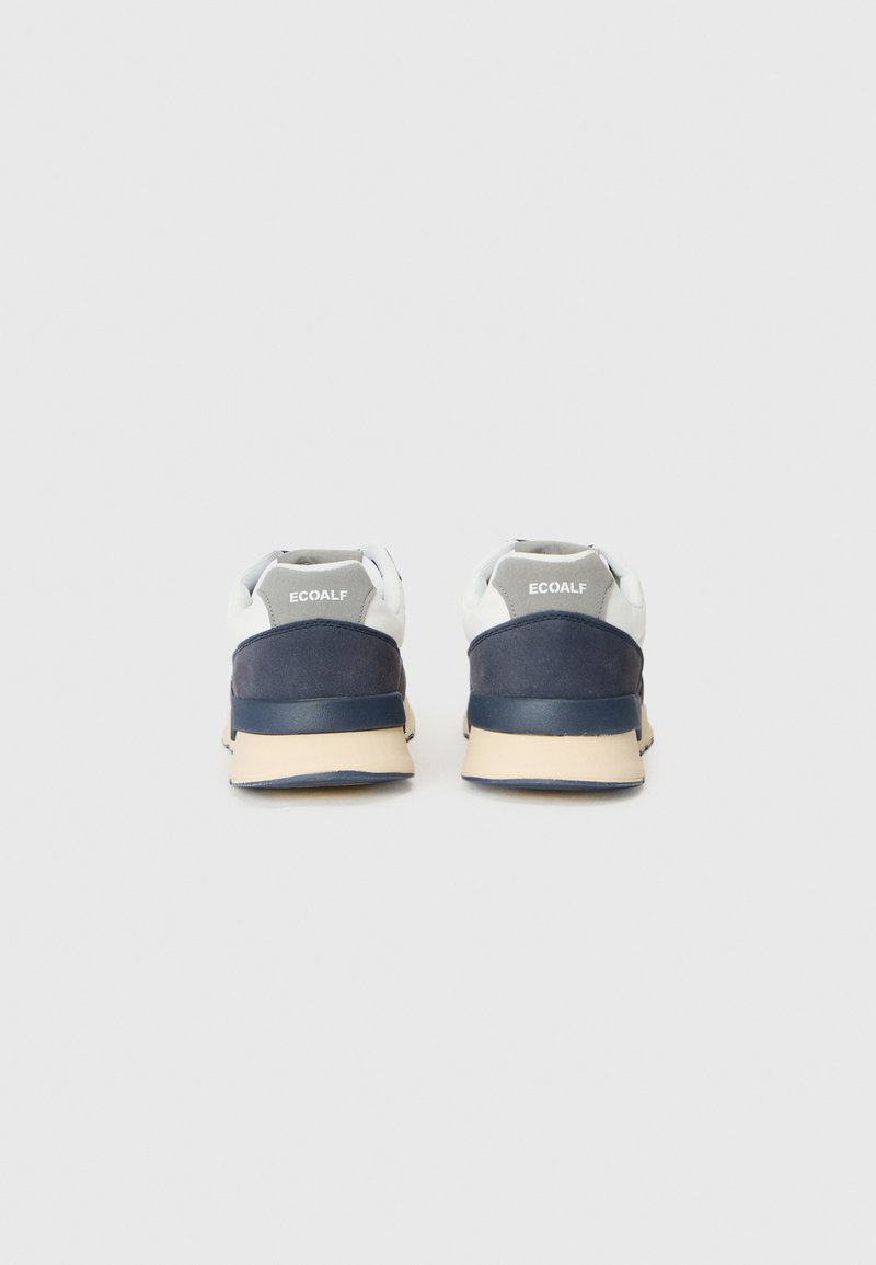 Zapatillas con cordones que presentan una combinación de colores en blanco y azul marino oscuro, materiales de ante y malla, punta redonda, con una suela de goma beige.