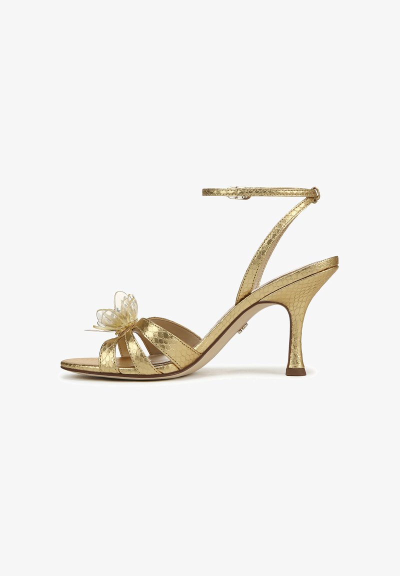 Gouden hoge haksandalen met een gestructureerde afwerking, voorzien van een vlinderaccent op de teen en een verstelbare enkelriem voor een goede pasvorm.