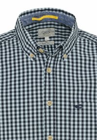 Camicia a quadrati in bianco e nero, con colletto in denim blu, bottoni beige e tasca con logo sul lato sinistro.